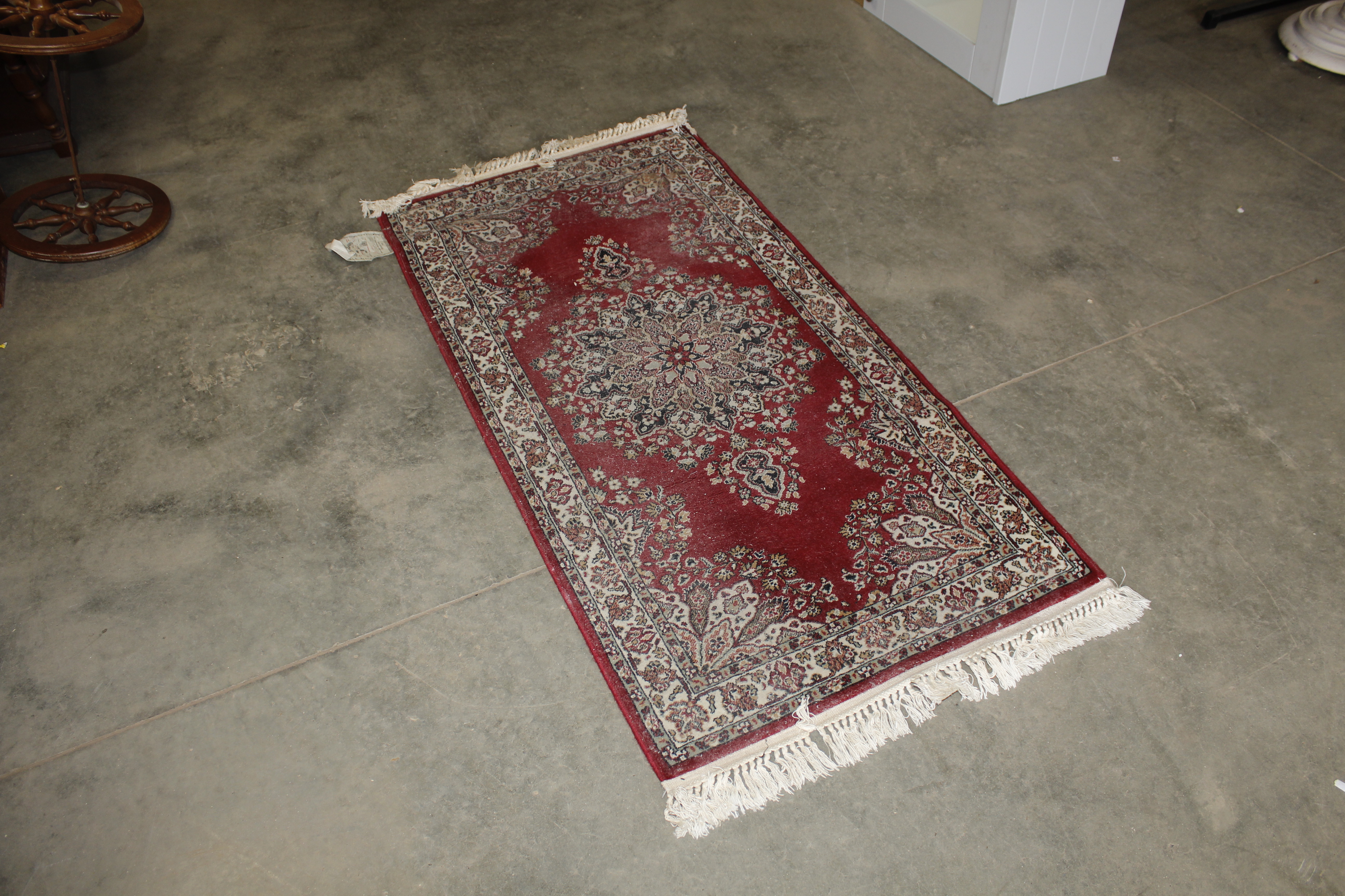 An approx. 5'7" x 2'7" floral patterned rug AF