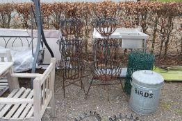 A pair of ornate wrought metal three tier planters