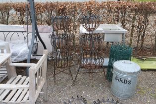 A pair of ornate wrought metal three tier planters