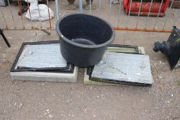 Two concrete surrounded manhole covers and a plast