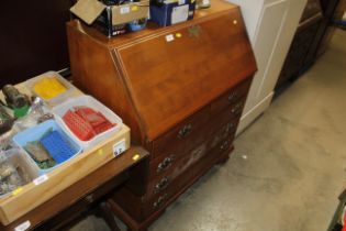 A reproduction mahogany bureau fitted two short ov