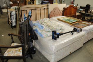 A divan bed with brass and iron head board and a m