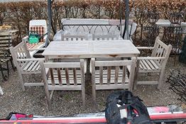 A teak garden table and set of six teak armchairs