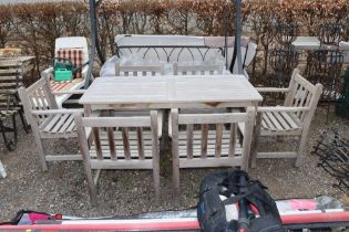 A teak garden table and set of six teak armchairs