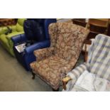 A floral upholstered wing back armchair