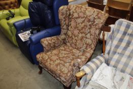 A floral upholstered wing back armchair
