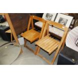 A pair of folding wooden chairs