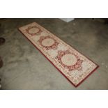An approx. 8'4" x 2'3" floral patterned rug