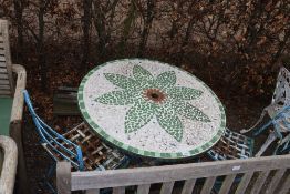A tiled topped pedestal circular garden table, mat