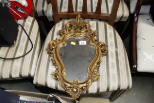 A cartouche shaped gilt framed wall mirror