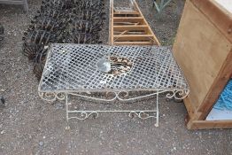 An ornate metal lattice topped garden table with fl