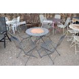 A circular lattice topped garden table and set of