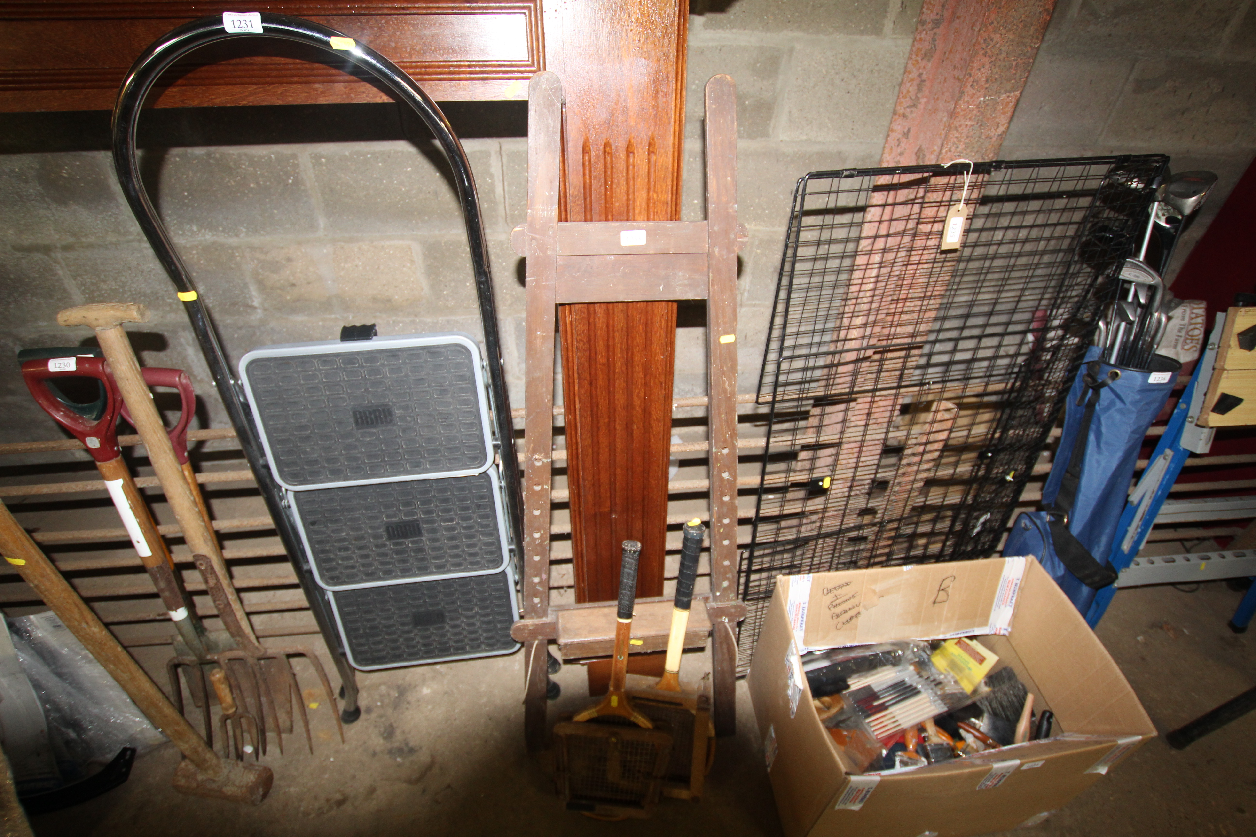 A wooden folding easel and two sports racquets