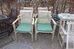 A set of four hardwood garden armchairs with cushi