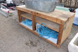 A large wooden plant potting bench fitted two shel