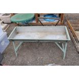 A galvanised trough on painted metal stand