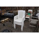 Four plastic stacking garden armchairs