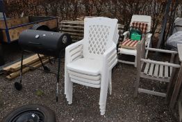 Four plastic stacking garden armchairs