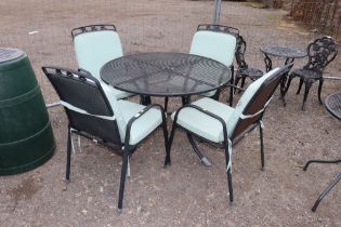 A large circular metal garden table and set of fou