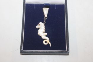 A mother of pearl pendant in the form of a seahors