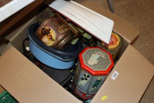 A box containing various vintage tins, model boat