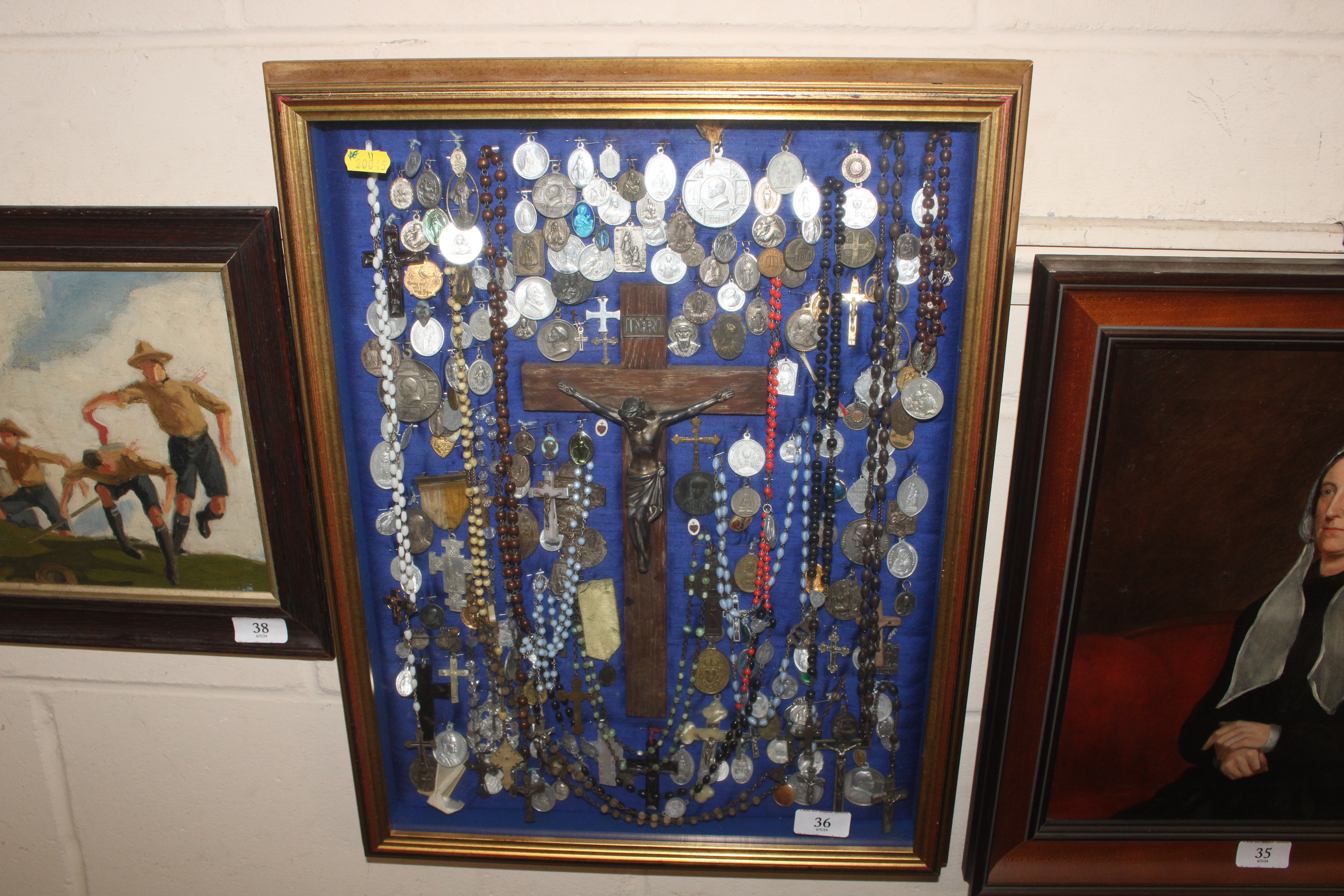 A display case of Papal medallions; rosary beads;