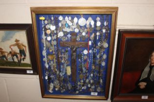 A display case of Papal medallions; rosary beads;