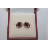 A pair of Sterling silver and garnet Halo stud ear