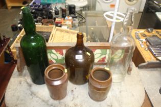 Three glass bottles and two stoneware jars