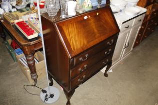A reproduction mahogany bureau fitted three drawer