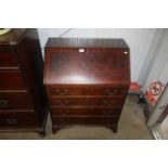 A reproduction mahogany bureau fitted four long dr