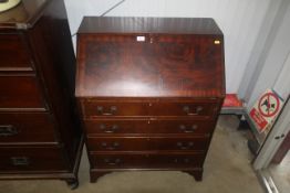 A reproduction mahogany bureau fitted four long dr