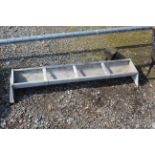 A galvanised four partitioned feed trough