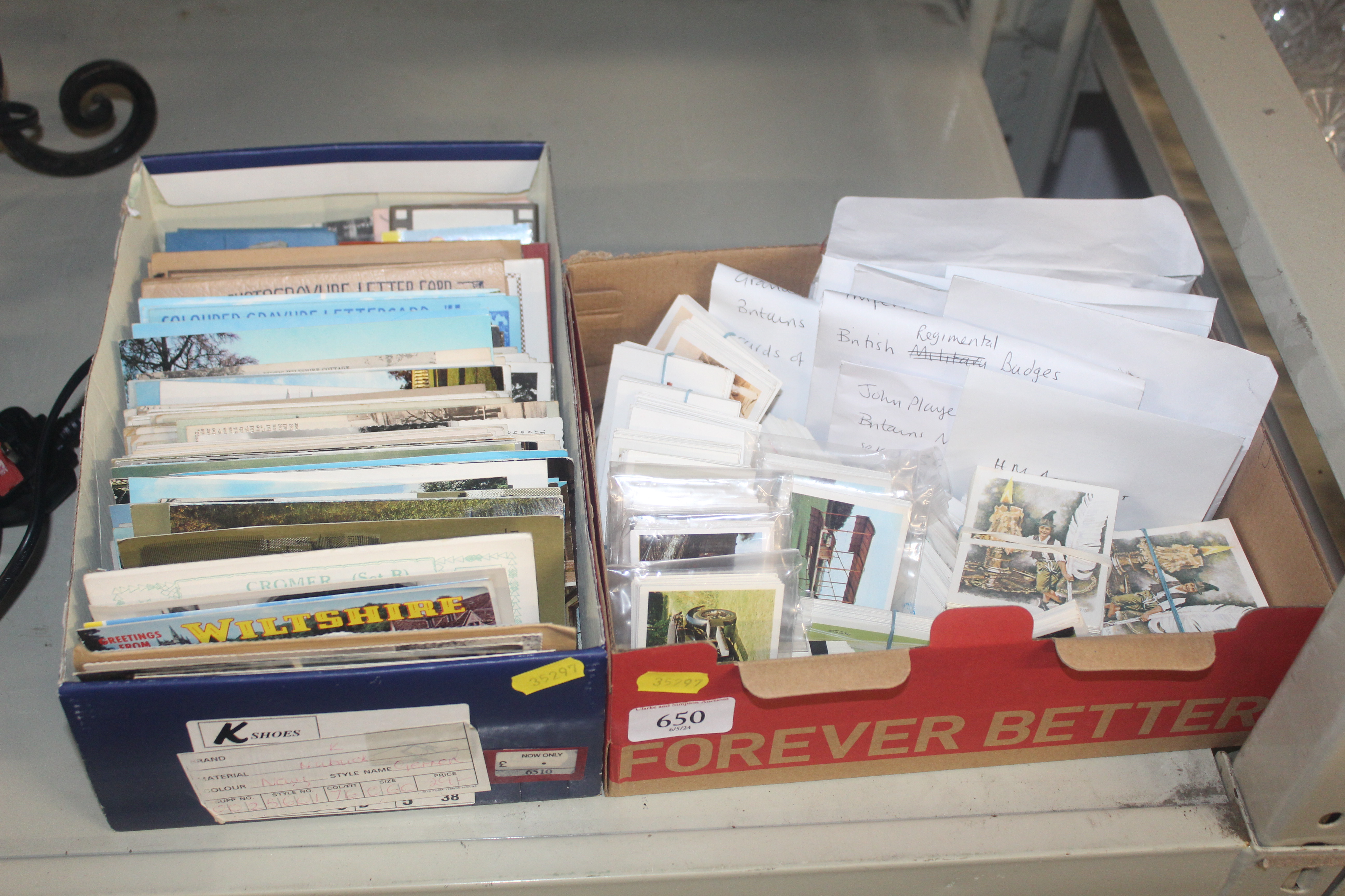 A box of various postcards and a box of collectors