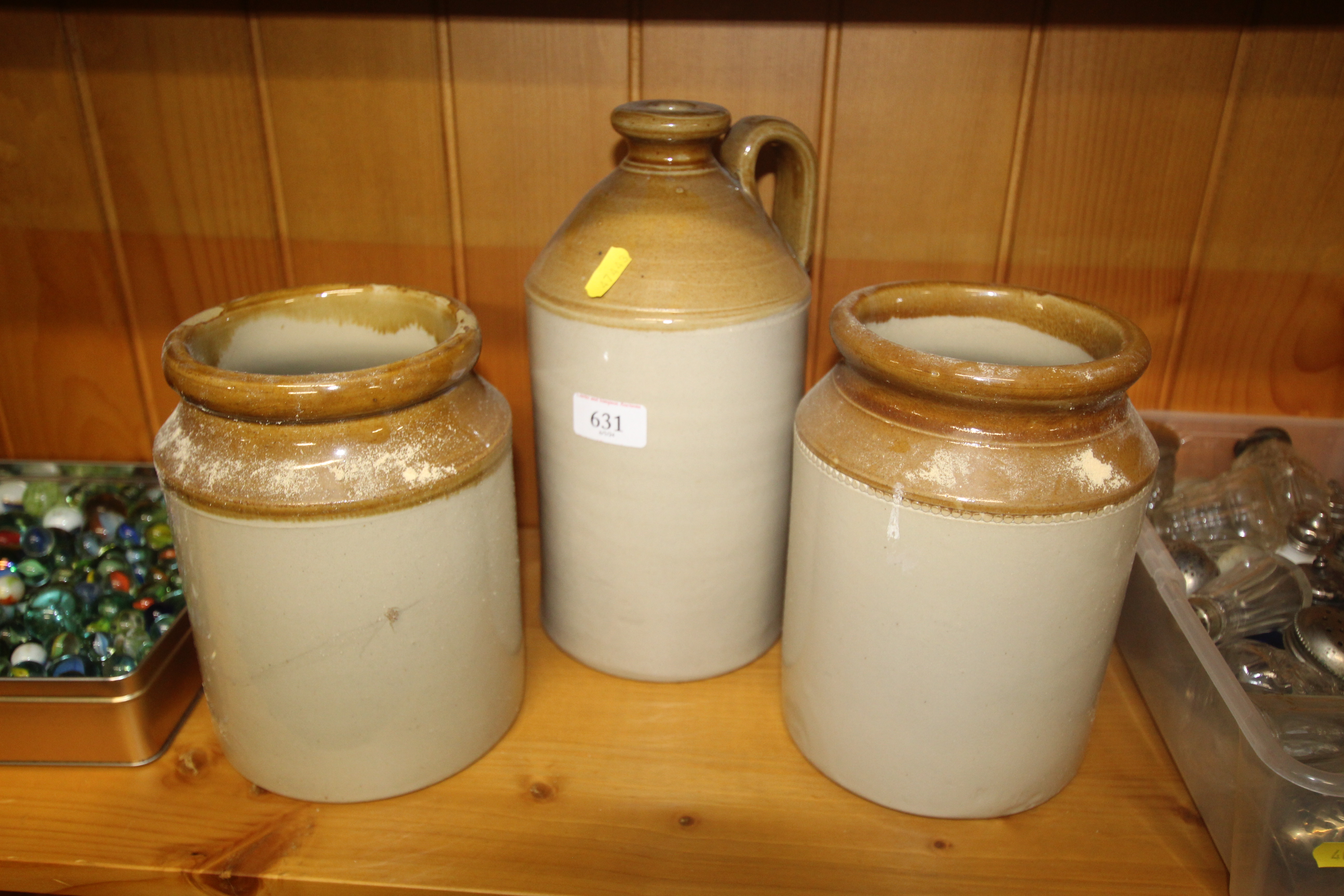 A stoneware bottle and two stoneware jars