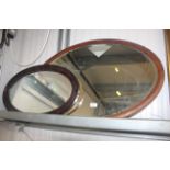 Two oval framed wall mirrors