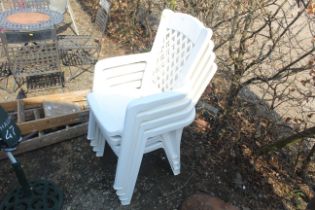 Four white plastic garden armchairs