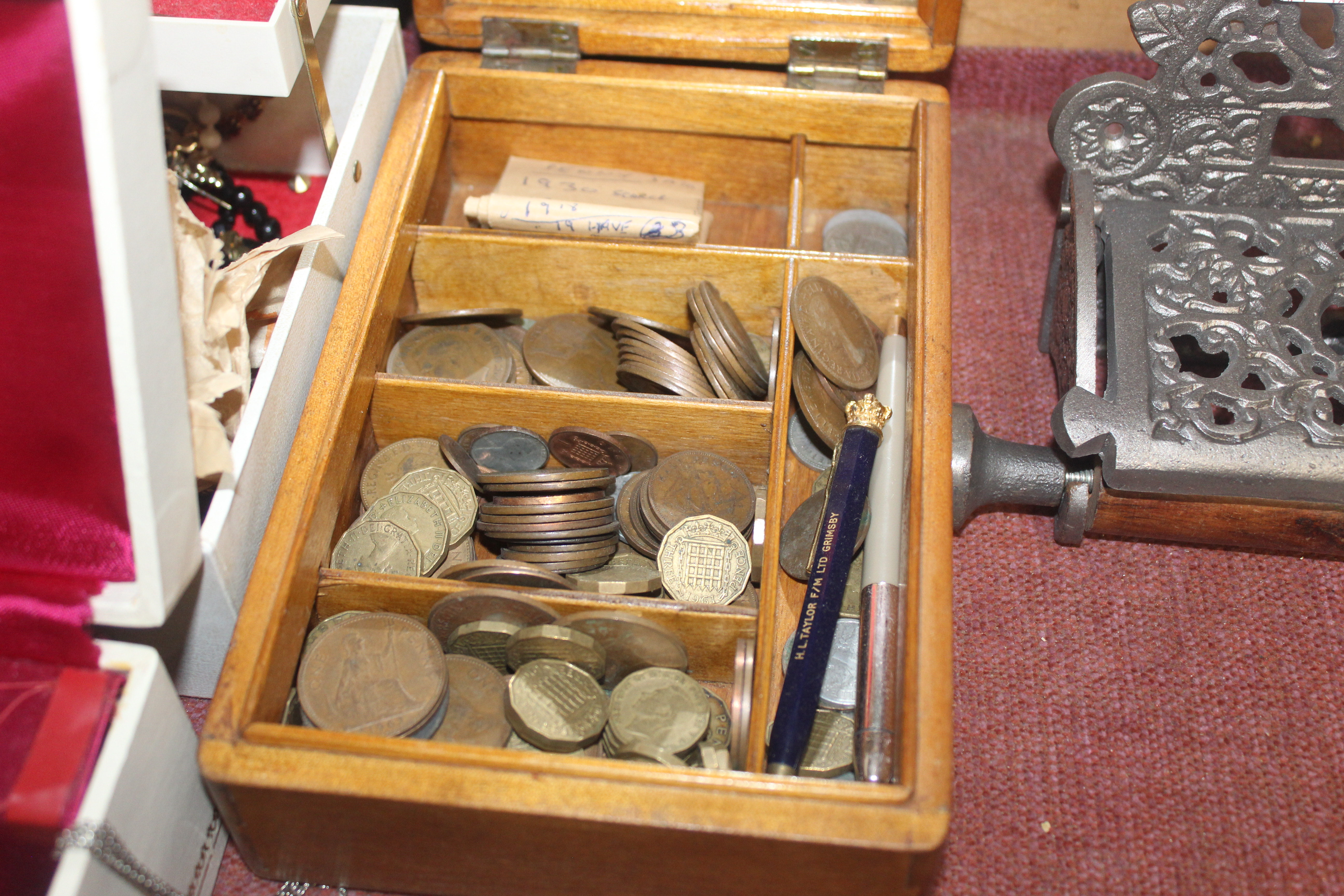 A wooden box with contents of various coins