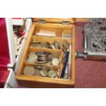 A wooden box with contents of various coins