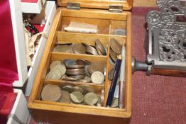 A wooden box with contents of various coins