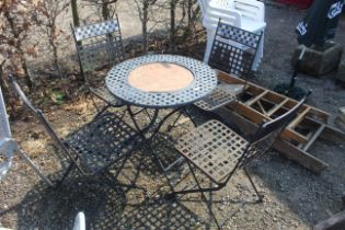 A metal lattice type circular garden table with se