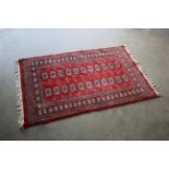 An approx. 5'7" x 3'2" red patterned rug