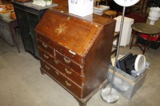 An antique inlaid bureau fitted two short over two