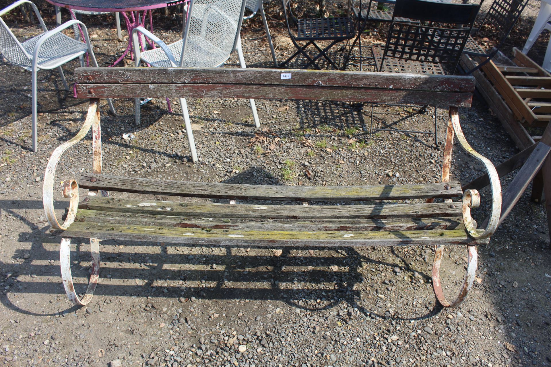 An ornate wrought iron garden bench with scroll en