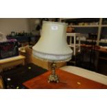 An ornate brass table lamp and shade