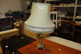 An ornate brass table lamp and shade