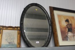 An oval framed and bevel edged wall mirror