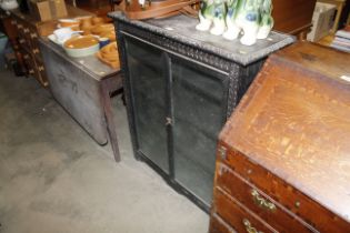 A late Victorian carved oak and glazed cabinet