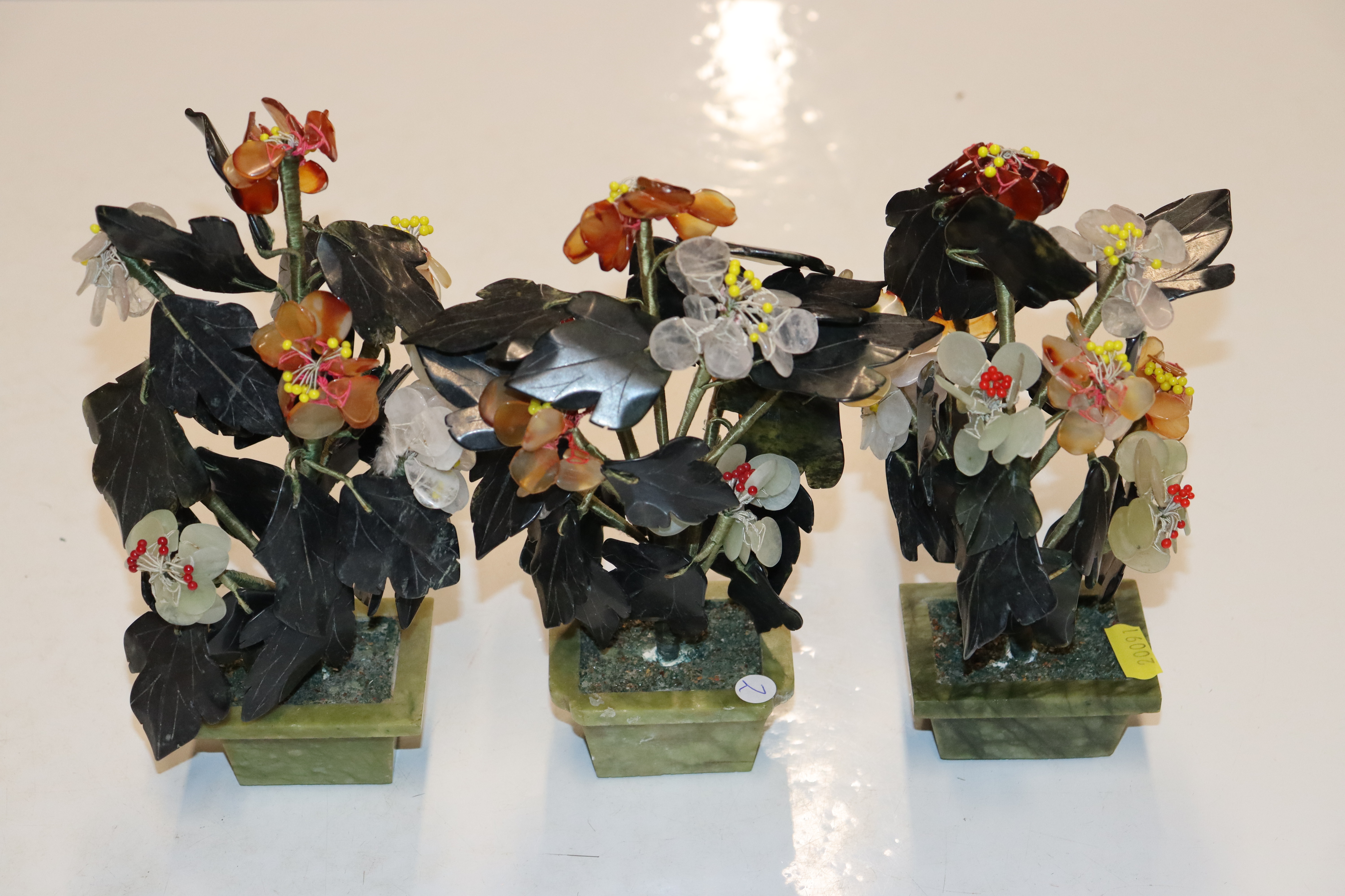 Three Chinese hardstone flower arrangements in pot