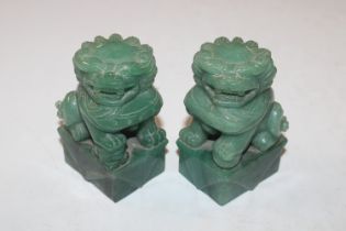 Two carved jade coloured stone Temple Dogs